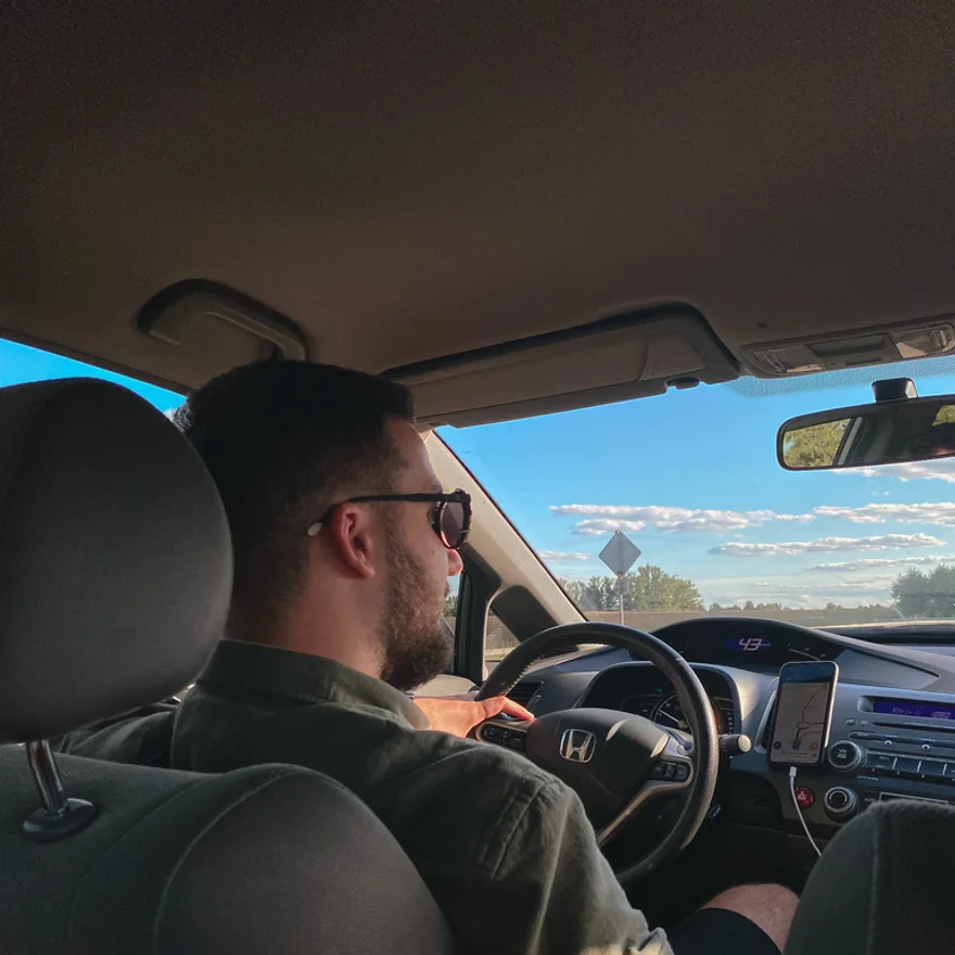 Max driving, sunglasses on, a road ahead